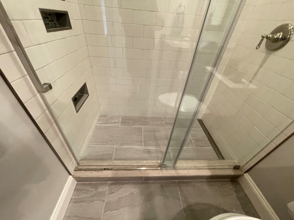 Alcove shower - mid-sized white tile and porcelain tile ceramic tile, gray floor and single-sink alcove shower idea in DC Metro with recessed-panel cabinets, gray cabinets, a two-piece toilet, gray walls, an undermount sink, quartz countertops, gray countertops, a niche and a built-in vanity