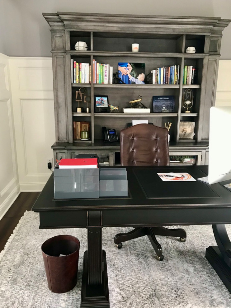 Photo of a mid-sized transitional study room in Philadelphia with grey walls, dark hardwood floors, no fireplace, a freestanding desk, brown floor and decorative wall panelling.