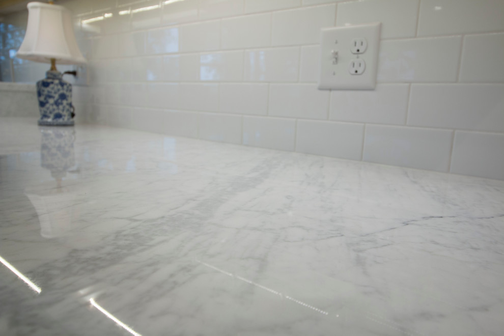 Inspiration for a huge transitional medium tone wood floor open concept kitchen remodel with an undermount sink, shaker cabinets, white cabinets, marble countertops, white backsplash, ceramic backsplash, stainless steel appliances and two islands