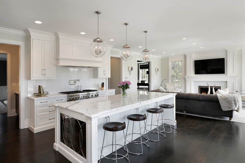 Design ideas for a large traditional l-shaped open plan kitchen in Chicago with recessed-panel cabinets, white cabinets, white splashback, dark hardwood floors and with island.