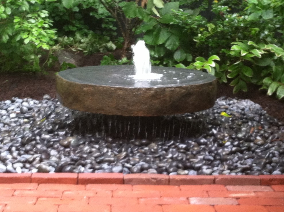 Traditional courtyard garden in Boston with a water feature and brick pavers.