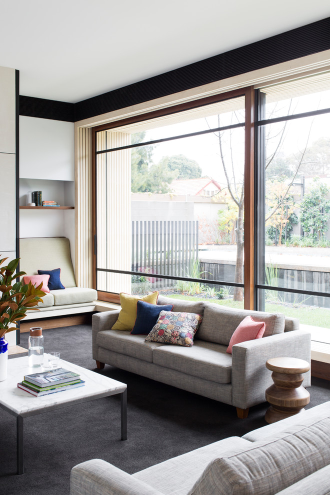 This is an example of a contemporary family room in Melbourne with carpet and white walls.