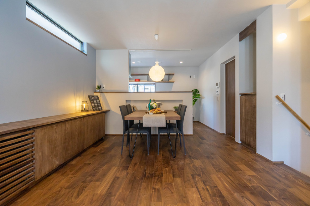 Foto på en minimalistisk matplats, med grå väggar, mellanmörkt trägolv och brunt golv