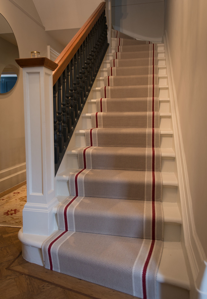Inspiration for a medium sized classic carpeted curved wood railing staircase in London with carpeted risers.