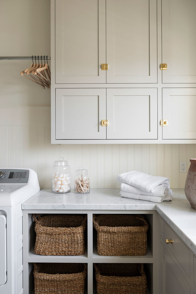 Inspiration for a large beach style l-shaped dedicated laundry room in Salt Lake City with grey cabinets, marble benchtops, white walls, ceramic floors, a side-by-side washer and dryer, grey floor and multi-coloured benchtop.