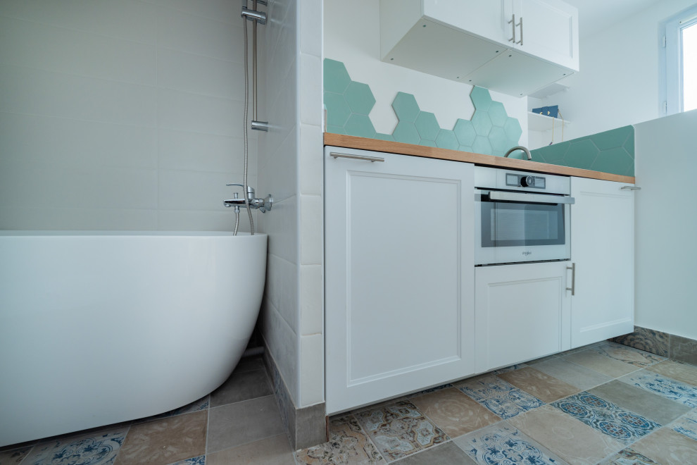 Idée de décoration pour une petite salle de bain principale nordique avec une baignoire posée, un carrelage blanc, des carreaux de céramique, un mur blanc, carreaux de ciment au sol, un sol bleu et une niche.