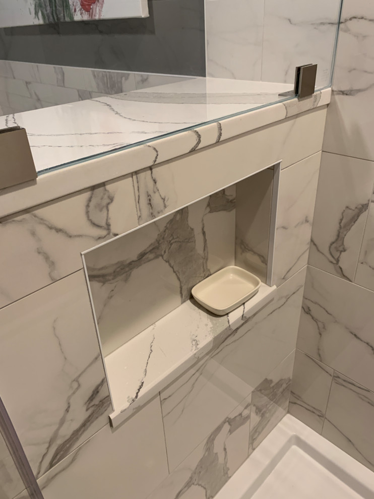 Modern inredning av ett mellanstort vit vitt en-suite badrum, med släta luckor, ett badkar i en alkov, en dusch/badkar-kombination, en toalettstol med separat cisternkåpa, flerfärgad kakel, porslinskakel, gröna väggar, klinkergolv i porslin, ett väggmonterat handfat, marmorbänkskiva och dusch med skjutdörr