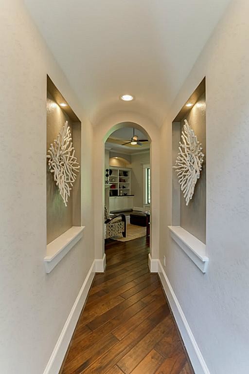 This is an example of a mid-sized arts and crafts hallway in Houston with beige walls and medium hardwood floors.