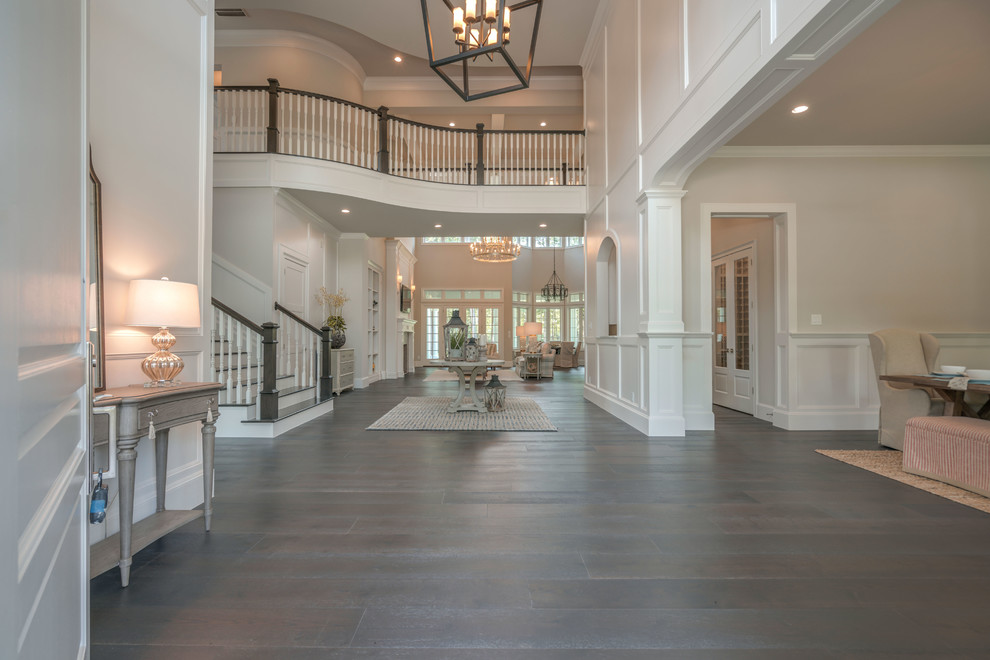 Design ideas for a large beach style foyer in Houston with white walls, dark hardwood floors, a single front door, a white front door, brown floor and wood walls.