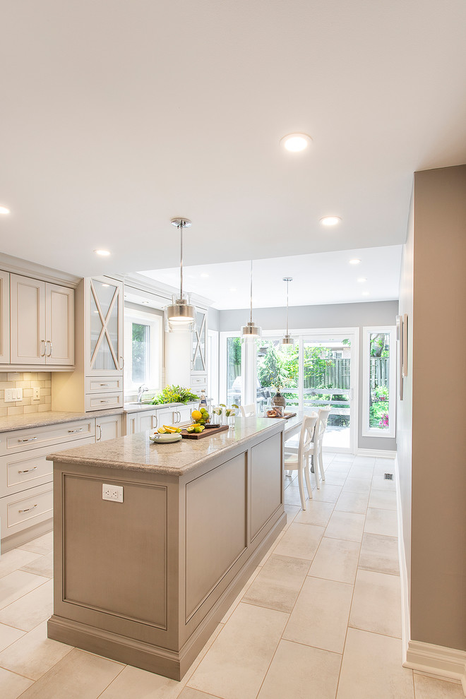 Inspiration for a mid-sized traditional u-shaped eat-in kitchen in Toronto with an undermount sink, recessed-panel cabinets, beige cabinets, granite benchtops, beige splashback, ceramic splashback, panelled appliances, porcelain floors, with island, beige floor and beige benchtop.