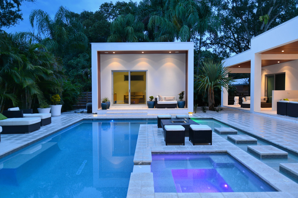 Design ideas for a large contemporary backyard custom-shaped lap pool in Tampa with a hot tub and concrete pavers.