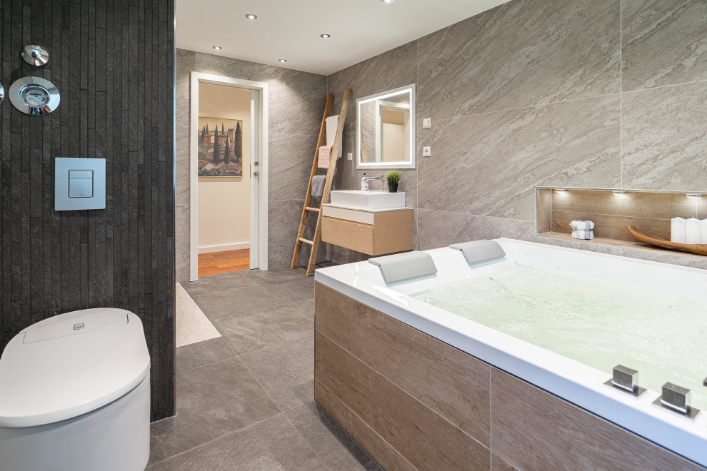 Badezimmer En Suite With hellen Holzschränken, Whirlpool, bodengleicher Dusche, Wandtoilette mit Spülkasten, braunen Fliesen, Steinfliesen, Aufsatzwaschbecken, Quarzit-Waschtisch, offener Dusche, weißer Waschtischplatte, Einzelwaschbecken and schwebendem Waschtisch in Berlin
