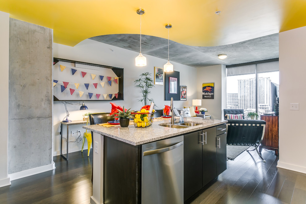 Example of a small transitional l-shaped medium tone wood floor and brown floor open concept kitchen design in Dallas with a double-bowl sink, flat-panel cabinets, dark wood cabinets, granite countertops, white backsplash, porcelain backsplash, stainless steel appliances and an island