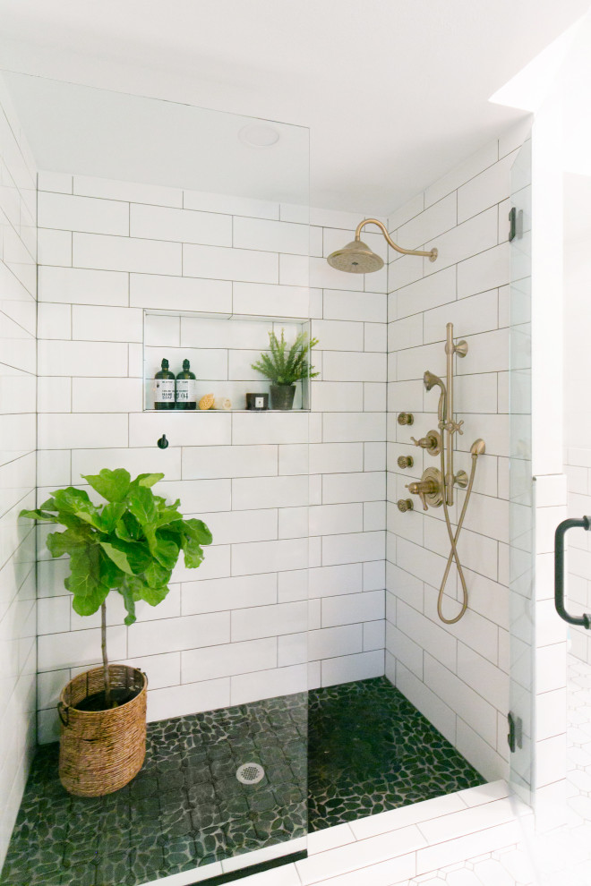 Photo of a mid-sized midcentury master bathroom in Minneapolis with flat-panel cabinets, medium wood cabinets, a freestanding tub, a corner shower, a one-piece toilet, white tile, subway tile, white walls, porcelain floors, an undermount sink, engineered quartz benchtops, white floor, a hinged shower door and multi-coloured benchtops.