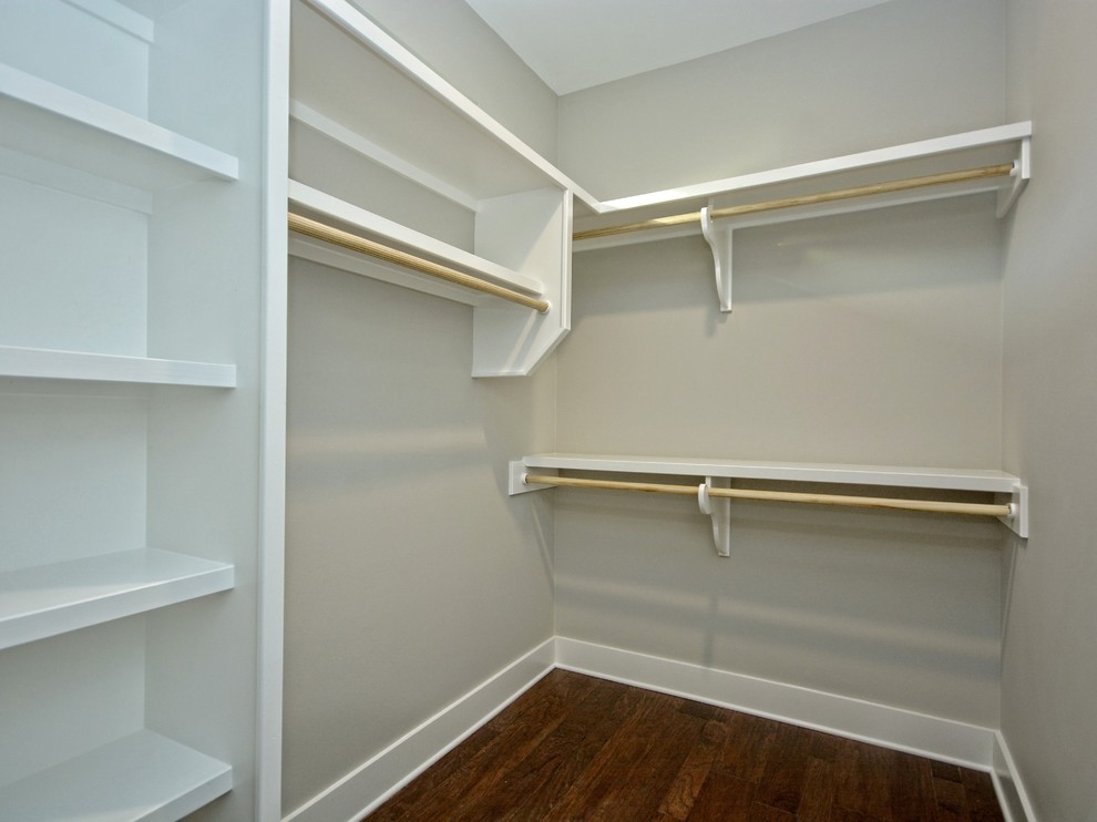 Large arts and crafts gender-neutral walk-in wardrobe in Austin with white cabinets and medium hardwood floors.