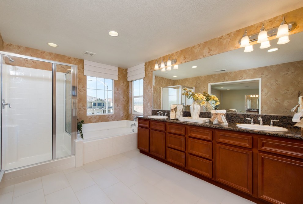 Photo of a large traditional master bathroom in Los Angeles with flat-panel cabinets, medium wood cabinets, a corner shower, granite benchtops, an alcove tub, white tile, porcelain tile, brown walls, porcelain floors, a drop-in sink, white floor, a hinged shower door and multi-coloured benchtops.