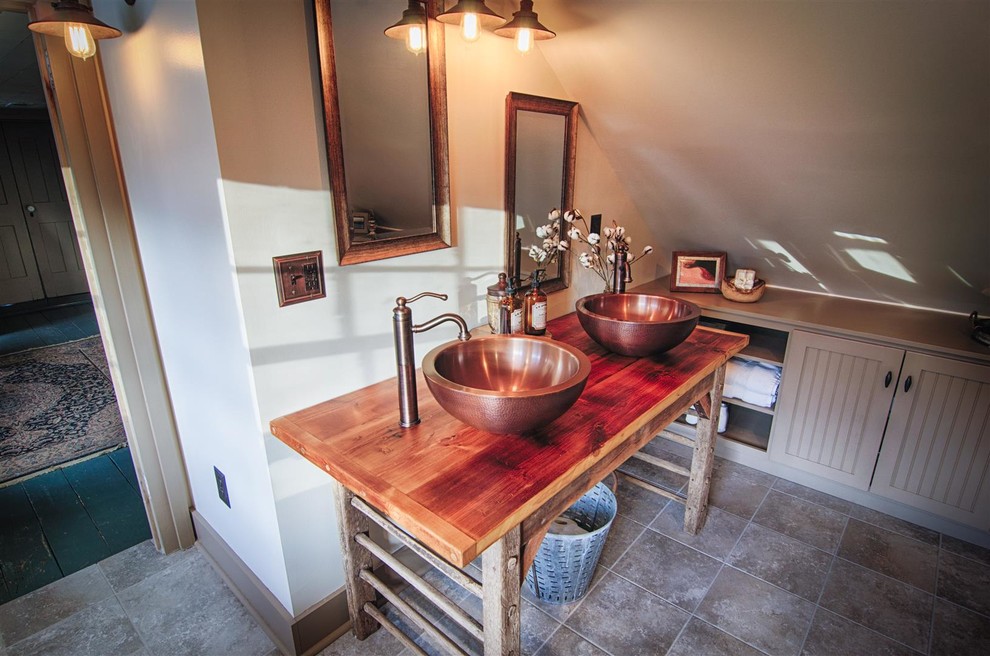 Photo of a mid-sized country master bathroom in Other with beaded inset cabinets, brown cabinets, a claw-foot tub, a corner shower, a two-piece toilet, brown tile, ceramic tile, beige walls, ceramic floors, a vessel sink and wood benchtops.