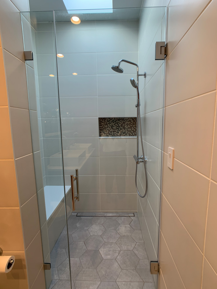 Photo of a transitional master bathroom in DC Metro with furniture-like cabinets, light wood cabinets, a curbless shower, a wall-mount toilet, beige tile, ceramic tile, red walls, porcelain floors, a vessel sink, engineered quartz benchtops, grey floor, a hinged shower door, white benchtops, a shower seat, a double vanity and a floating vanity.