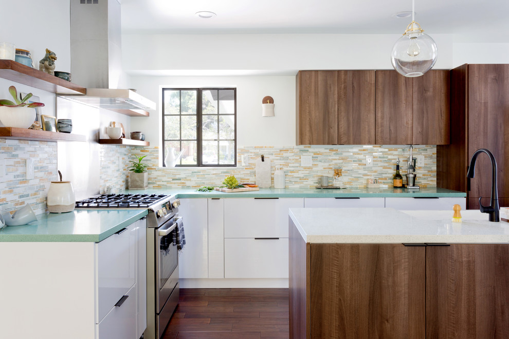 Midcentury l-shaped kitchen in Orange County with a farmhouse sink, flat-panel cabinets, dark wood cabinets, multi-coloured splashback, matchstick tile splashback, panelled appliances, dark hardwood floors, with island, brown floor and green benchtop.