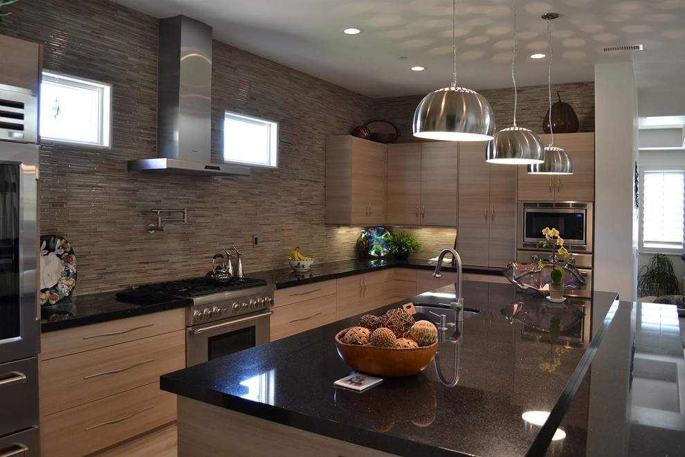 Photo of a modern l-shaped separate kitchen in Los Angeles with flat-panel cabinets, medium wood cabinets, granite benchtops, multi-coloured splashback, matchstick tile splashback, stainless steel appliances, vinyl floors and with island.