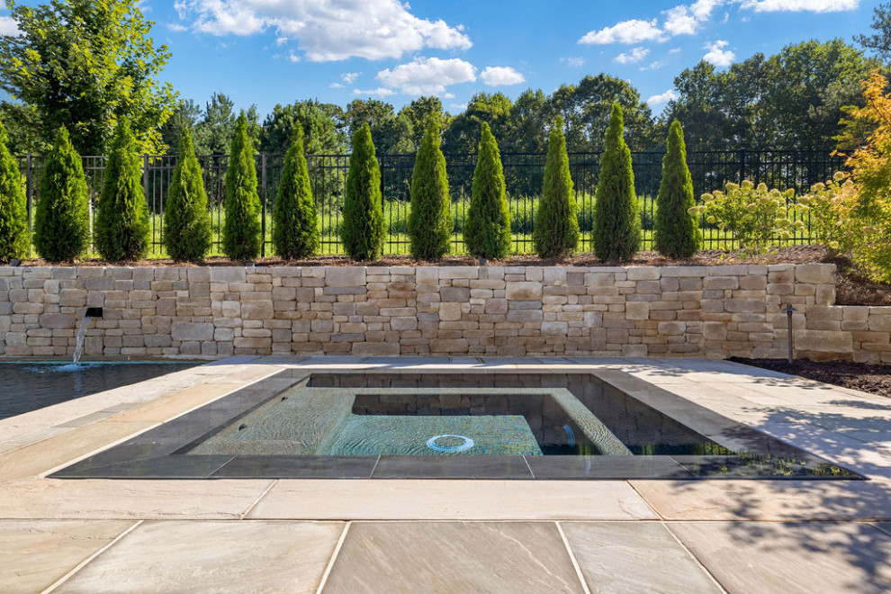 Inspiration for a large contemporary backyard rectangular infinity pool in Atlanta with a hot tub and natural stone pavers.