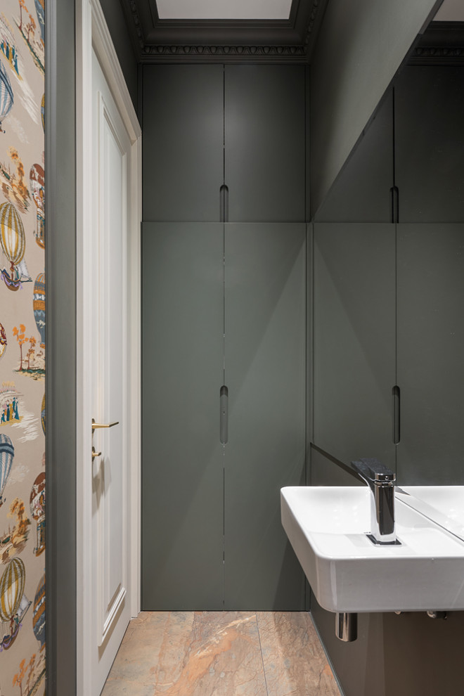 Small eclectic powder room in Moscow with flat-panel cabinets, green cabinets, a wall-mount toilet, green walls, porcelain floors, a wall-mount sink, brown floor and wallpaper.