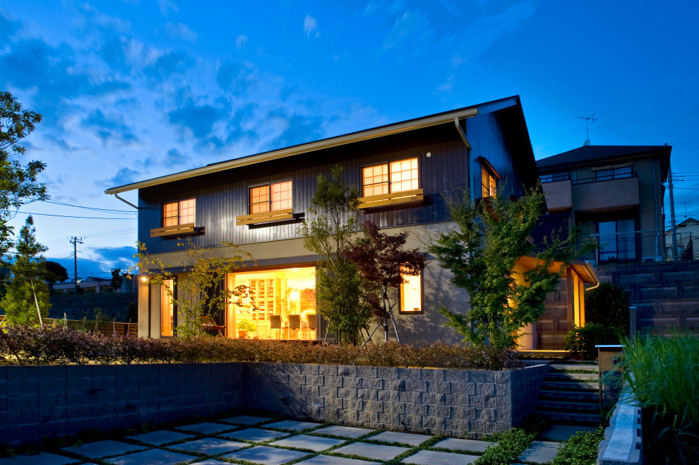 Diseño de fachada de casa gris moderna de tamaño medio de dos plantas con tejado a dos aguas y tejado de metal