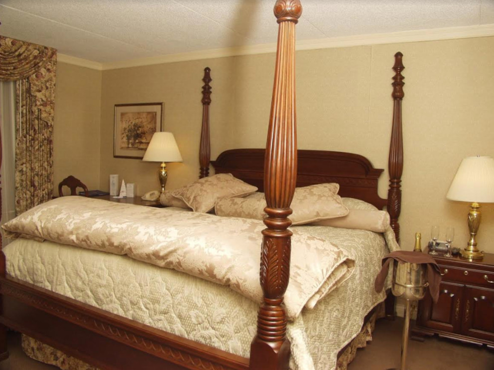 Photo of a large traditional guest bedroom in Newark with beige walls and carpet.