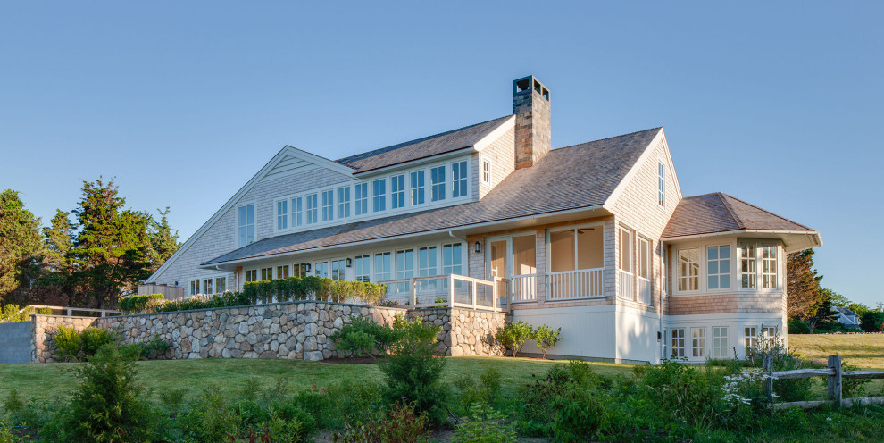 This is an example of a beach style exterior in Boston with wood siding and a shingle roof.