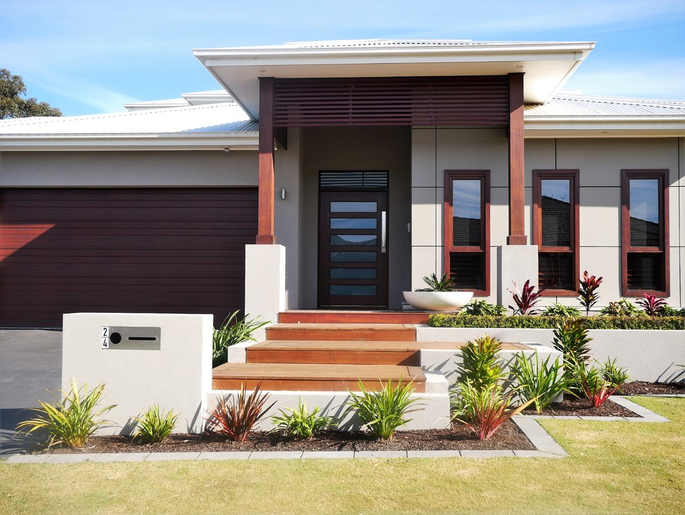 Photo of a mid-sized tropical one-storey beige house exterior in Sydney with a hip roof and a metal roof.