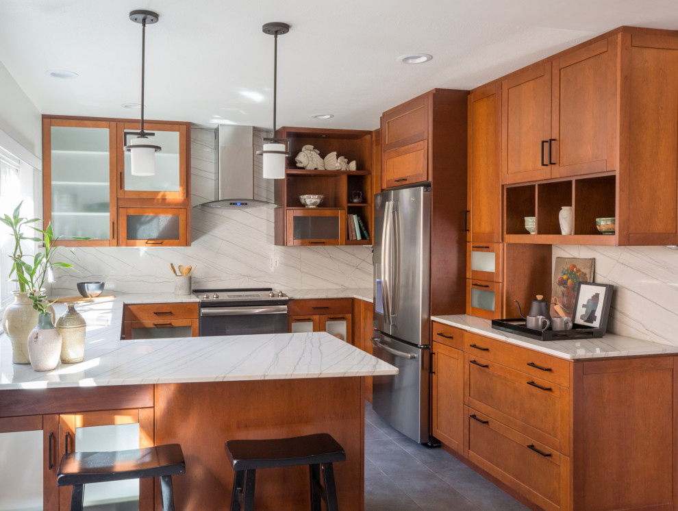 This is an example of a small transitional u-shaped eat-in kitchen in San Diego with an undermount sink, shaker cabinets, quartzite benchtops, white splashback, stone slab splashback, stainless steel appliances, porcelain floors, no island, grey floor, white benchtop and medium wood cabinets.