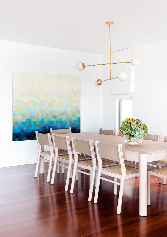 Photo of a beach style dining room in Brisbane with white walls, medium hardwood floors and no fireplace.