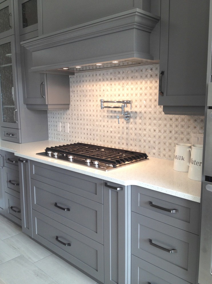 Mid-sized transitional single-wall porcelain tile eat-in kitchen photo in Toronto with shaker cabinets, gray cabinets, quartzite countertops, white backsplash, mosaic tile backsplash and stainless steel appliances