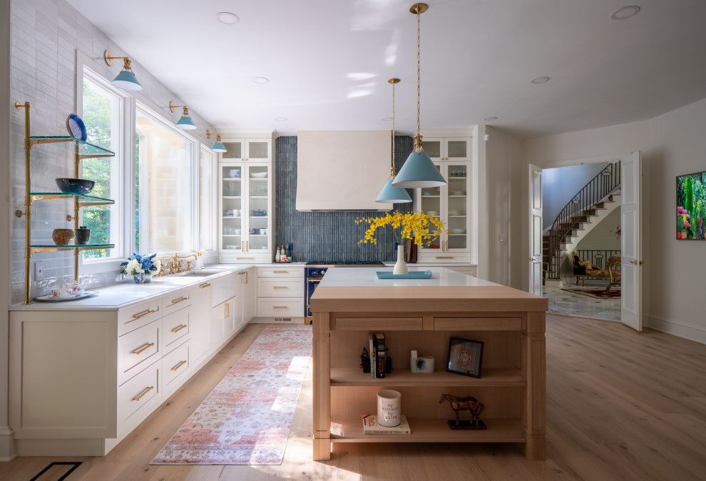 Inspiration for a large transitional u-shaped light wood floor and brown floor eat-in kitchen remodel in DC Metro with a farmhouse sink, shaker cabinets, beige cabinets, quartzite countertops, blue backsplash, ceramic backsplash, stainless steel appliances, an island and white countertops