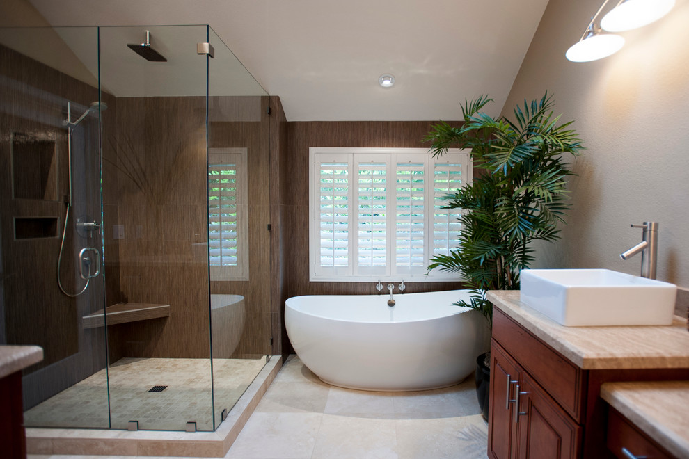 Large contemporary master bathroom in San Diego with a freestanding tub, a vessel sink, medium wood cabinets, a corner shower, beige walls, ceramic floors, limestone benchtops, a hinged shower door and recessed-panel cabinets.