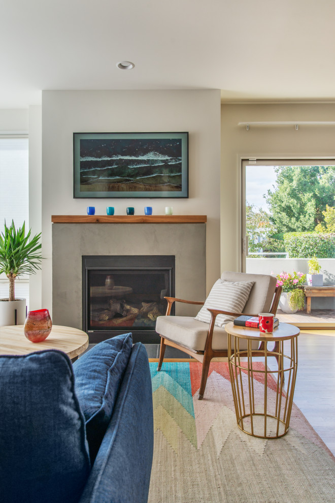 Inspiration for a mid-sized contemporary formal open concept living room in Seattle with white walls, light hardwood floors, a standard fireplace, a concrete fireplace surround and beige floor.