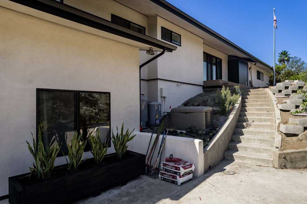 Geräumiges, Zweistöckiges Retro Einfamilienhaus mit Putzfassade, weißer Fassadenfarbe und grauem Dach in San Diego