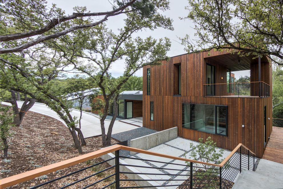 Photo of a contemporary two-storey exterior in Austin with wood siding and a flat roof.