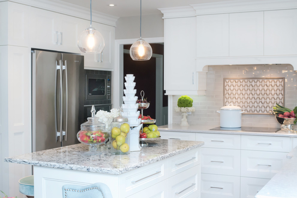 Mid-sized transitional u-shaped eat-in kitchen photo in Toronto with shaker cabinets, white cabinets, white backsplash, an island, quartz countertops and stainless steel appliances