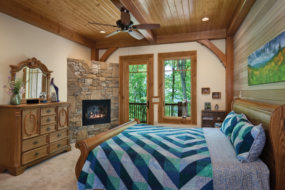 This is an example of a country master bedroom in Other with carpet, a corner fireplace, a stone fireplace surround, beige walls and beige floor.