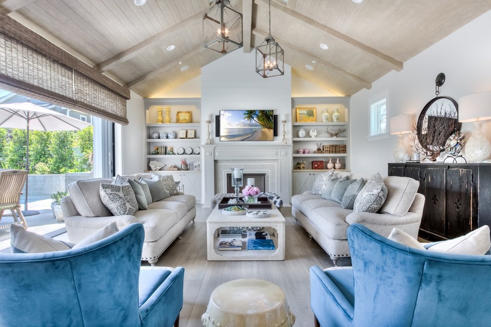 Design ideas for a country living room in Orange County with white walls, light hardwood floors, a standard fireplace and a wall-mounted tv.
