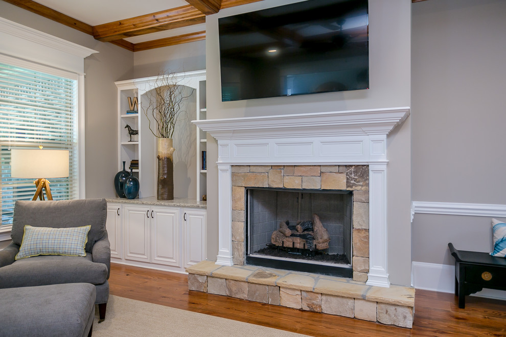 Photo of a large arts and crafts open concept family room in Atlanta with beige walls, a standard fireplace, a stone fireplace surround and a wall-mounted tv.