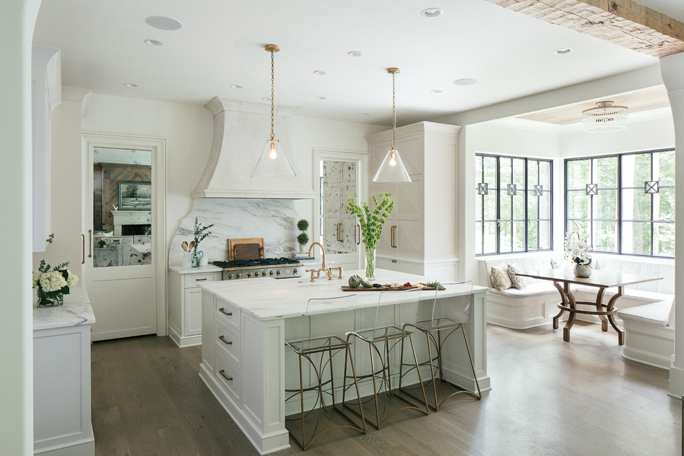 Design ideas for a large transitional l-shaped eat-in kitchen in Atlanta with a farmhouse sink, shaker cabinets, white cabinets, marble benchtops, white splashback, marble splashback, stainless steel appliances, dark hardwood floors, with island and brown floor.