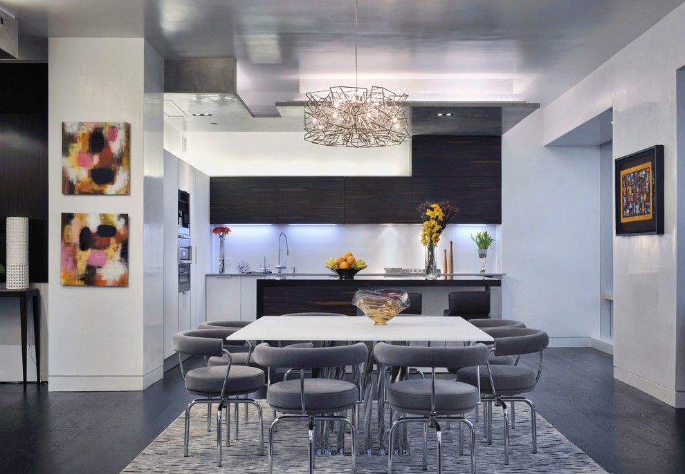 This is an example of a mid-sized contemporary l-shaped eat-in kitchen in New York with white splashback, dark hardwood floors, with island, stainless steel appliances, flat-panel cabinets, white cabinets and black floor.