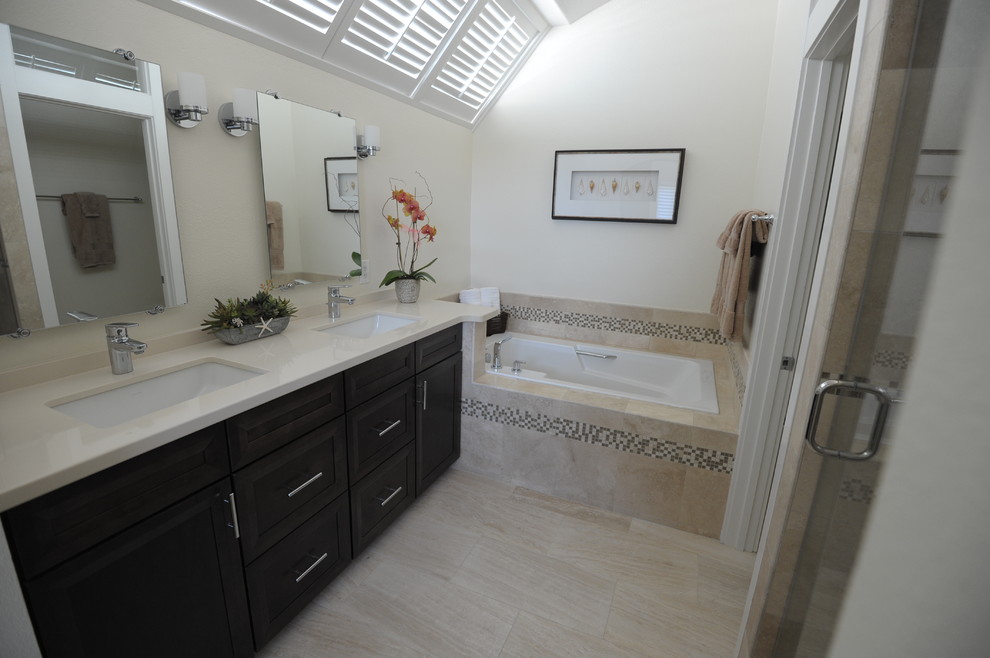 Design ideas for a mid-sized contemporary master bathroom in Orange County with an undermount sink, shaker cabinets, dark wood cabinets, engineered quartz benchtops, a drop-in tub, a one-piece toilet, beige tile, stone tile and travertine floors.