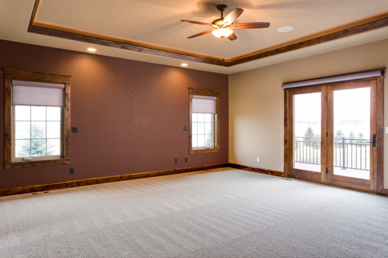 Inspiration for a large rustic carpeted bedroom remodel with a standard fireplace and a stone fireplace
