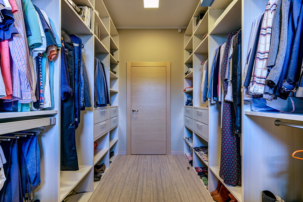 Modelo de armario vestidor unisex nórdico de tamaño medio con armarios con paneles lisos, puertas de armario de madera oscura, suelo de madera en tonos medios y suelo marrón