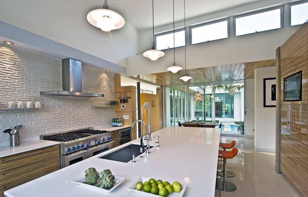 Inspiration for a modern galley eat-in kitchen in Miami with an undermount sink, flat-panel cabinets, light wood cabinets, quartz benchtops, white splashback, subway tile splashback and stainless steel appliances.