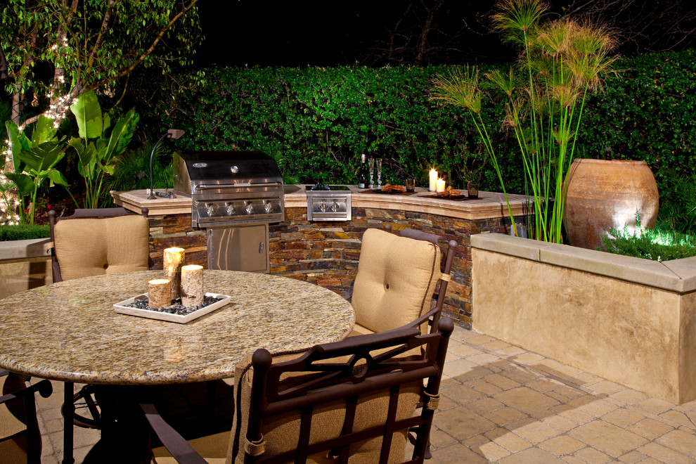 Design ideas for a tropical patio in Orange County with brick pavers.