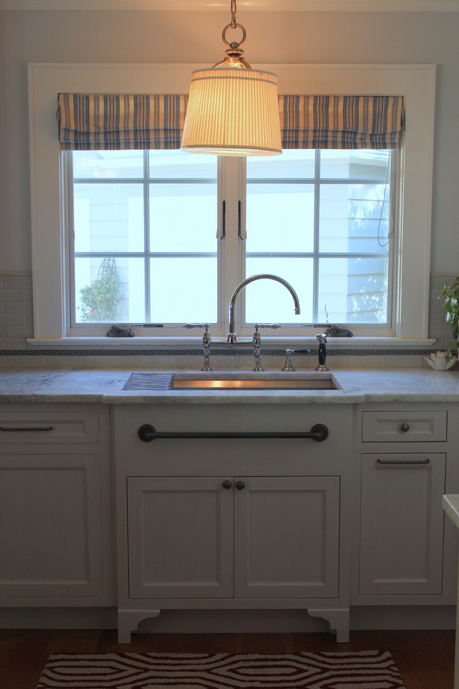 Open concept kitchen - large transitional u-shaped medium tone wood floor open concept kitchen idea in New York with a double-bowl sink, beaded inset cabinets, gray cabinets, quartzite countertops, blue backsplash, subway tile backsplash, black appliances and an island